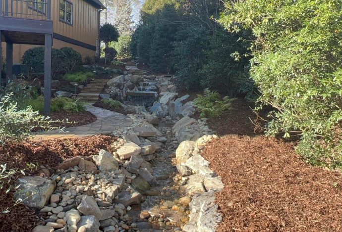 Backyard stream and waterfall with natural stone steps built by Toms Creek